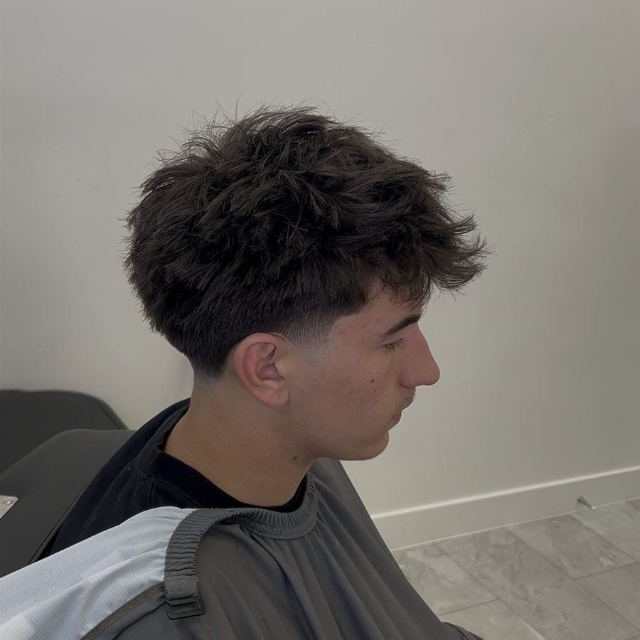 Client haircut with textured top and side fade, right profile
