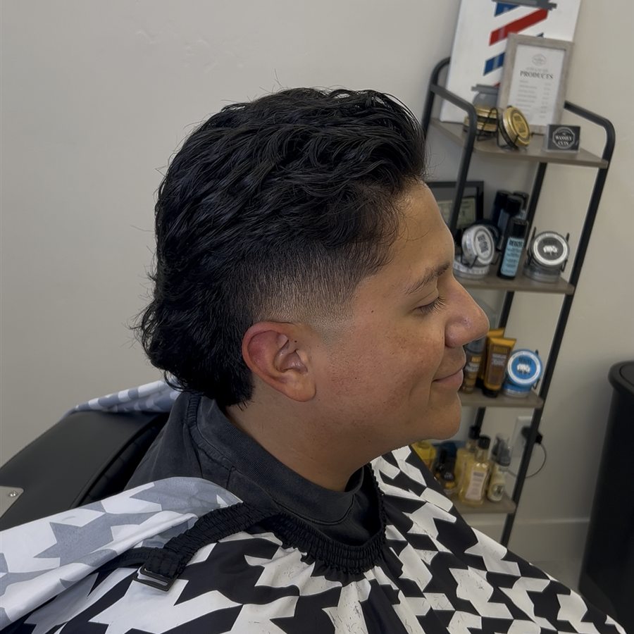 Client haircut with longer top and tapered side, left profile